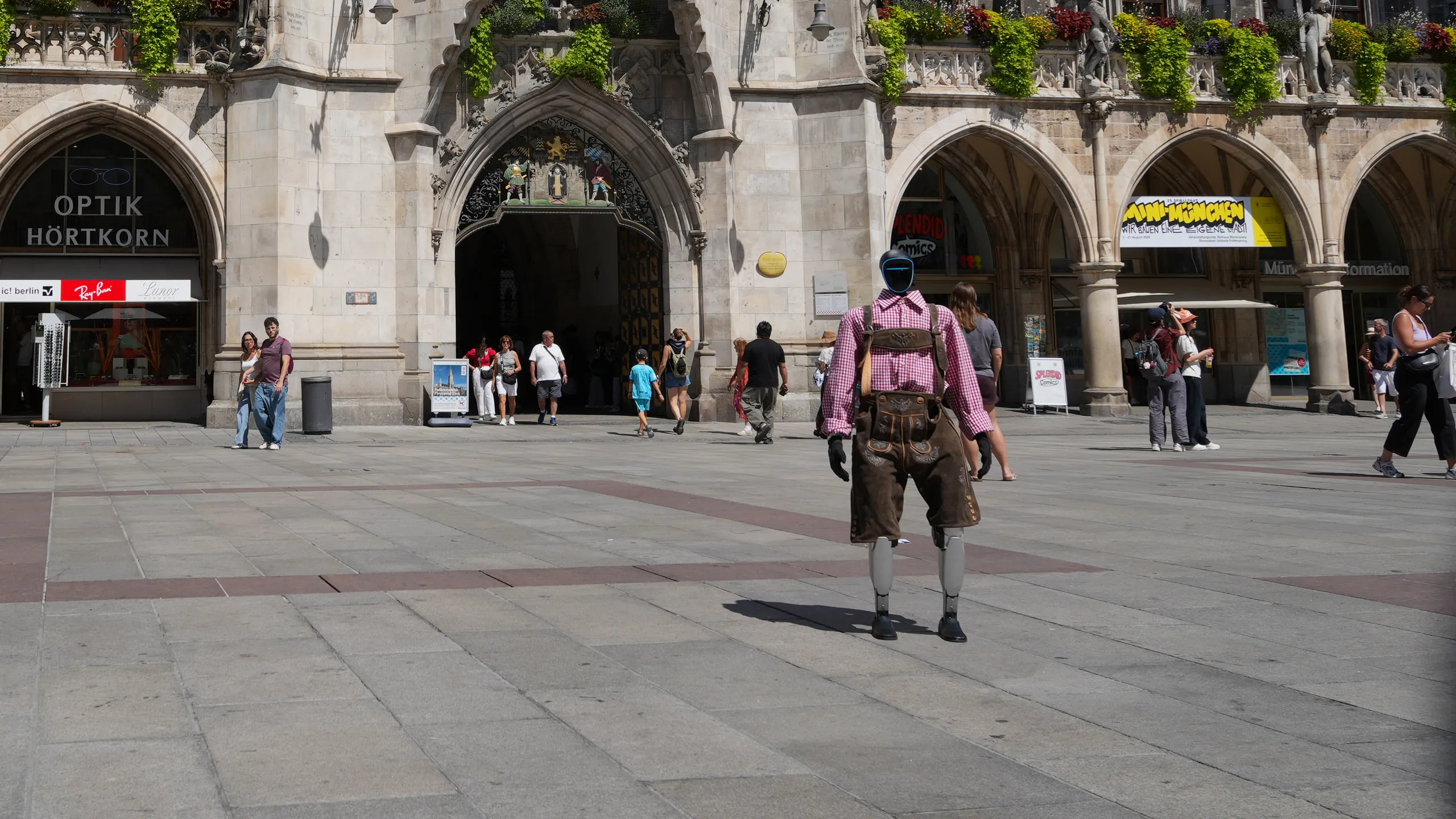 Humanoid robot in Lederhosen walking across Munich's Marienplatz towards the New Town Hall